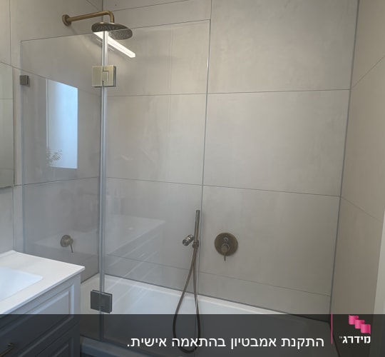 מקלחת עם דלת זכוכית וברזים מודרניים